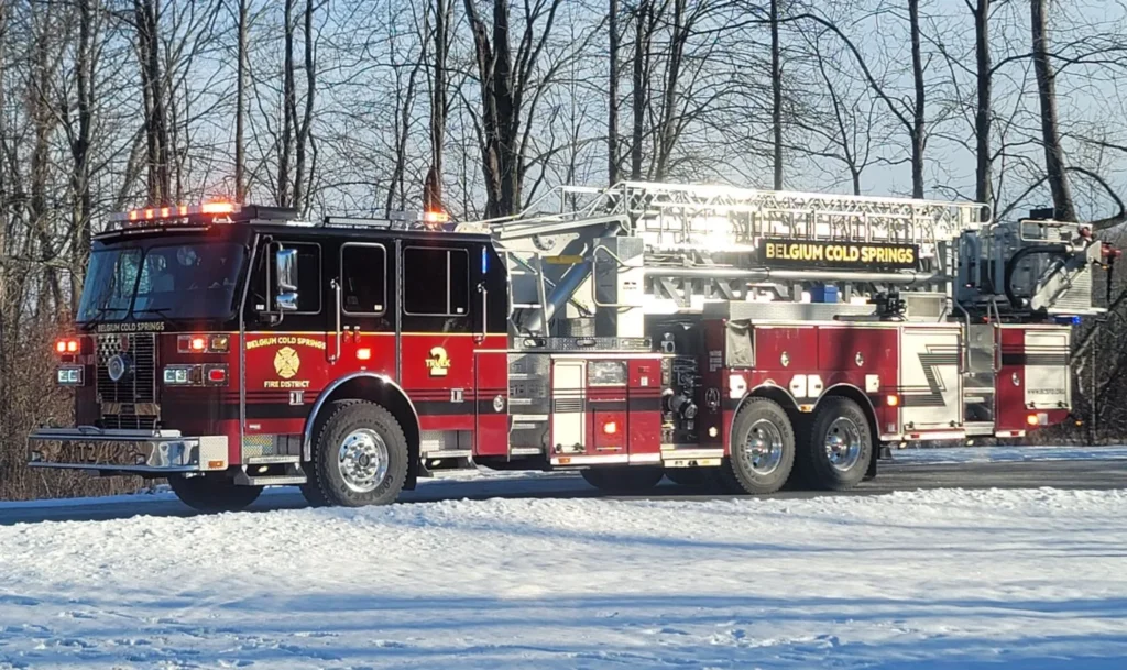 A Belgium Cold Spring fire truck with red emergency lights lit up